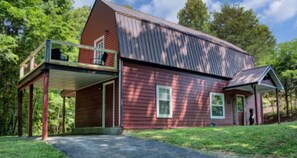 Standalone building with a covered porch, surrounded by lush greenery.