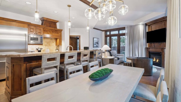A modern kitchen with a central island, stainless steel appliances, and a fireplace. - The Aspen Mountain Residences 03B (Aspen)