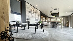 A modern interior with a dining area, kitchen, and large windows. - Lu T'Chêne - dans le Village d'Opont (Opont)