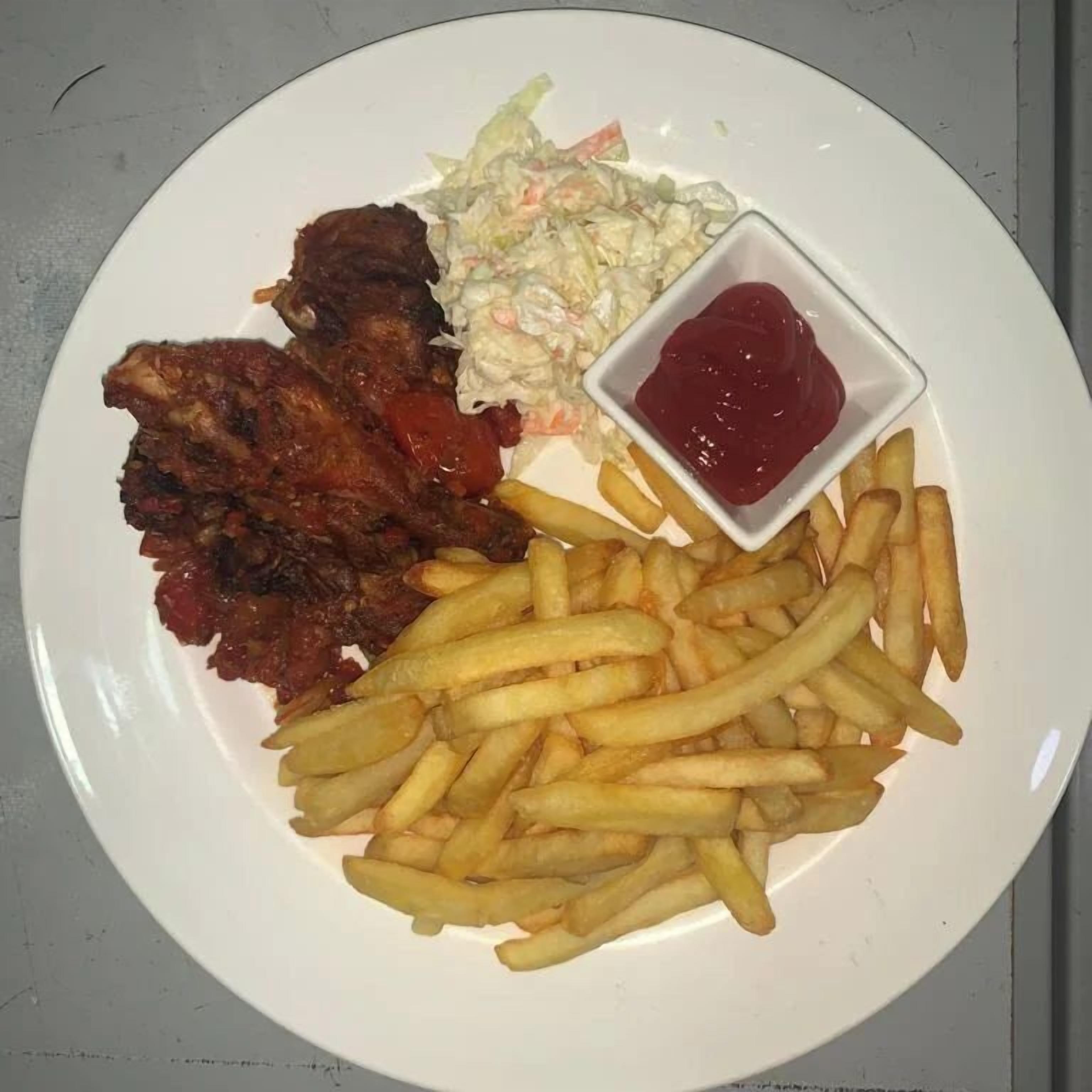A plate with fried chicken, coleslaw, fries, and ketchup.