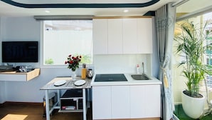 Una cucina compatta con piano cottura integrato, lavello e un piccolo spazio pranzo.