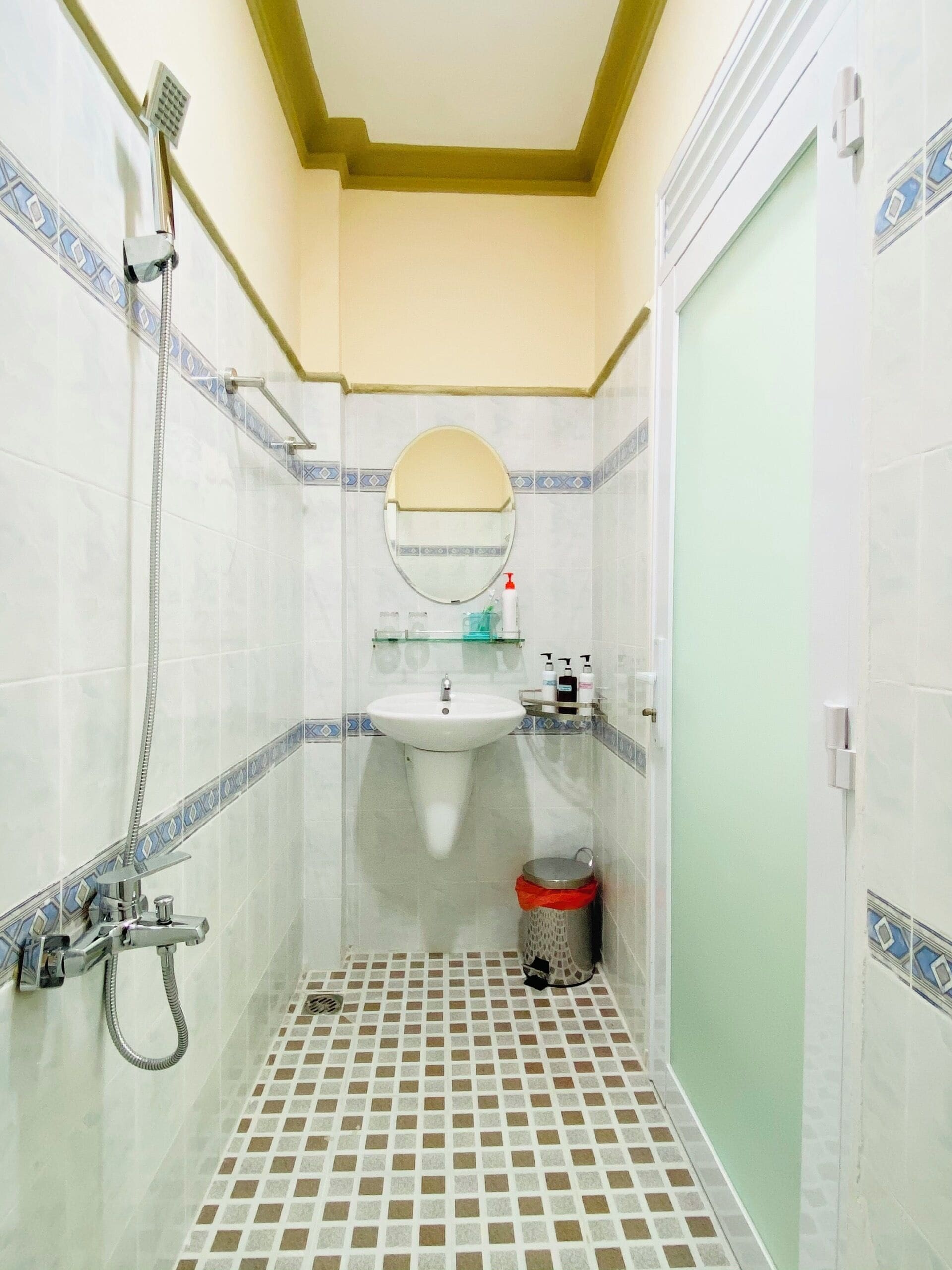 A small bathroom with a shower, sink, and toilet.