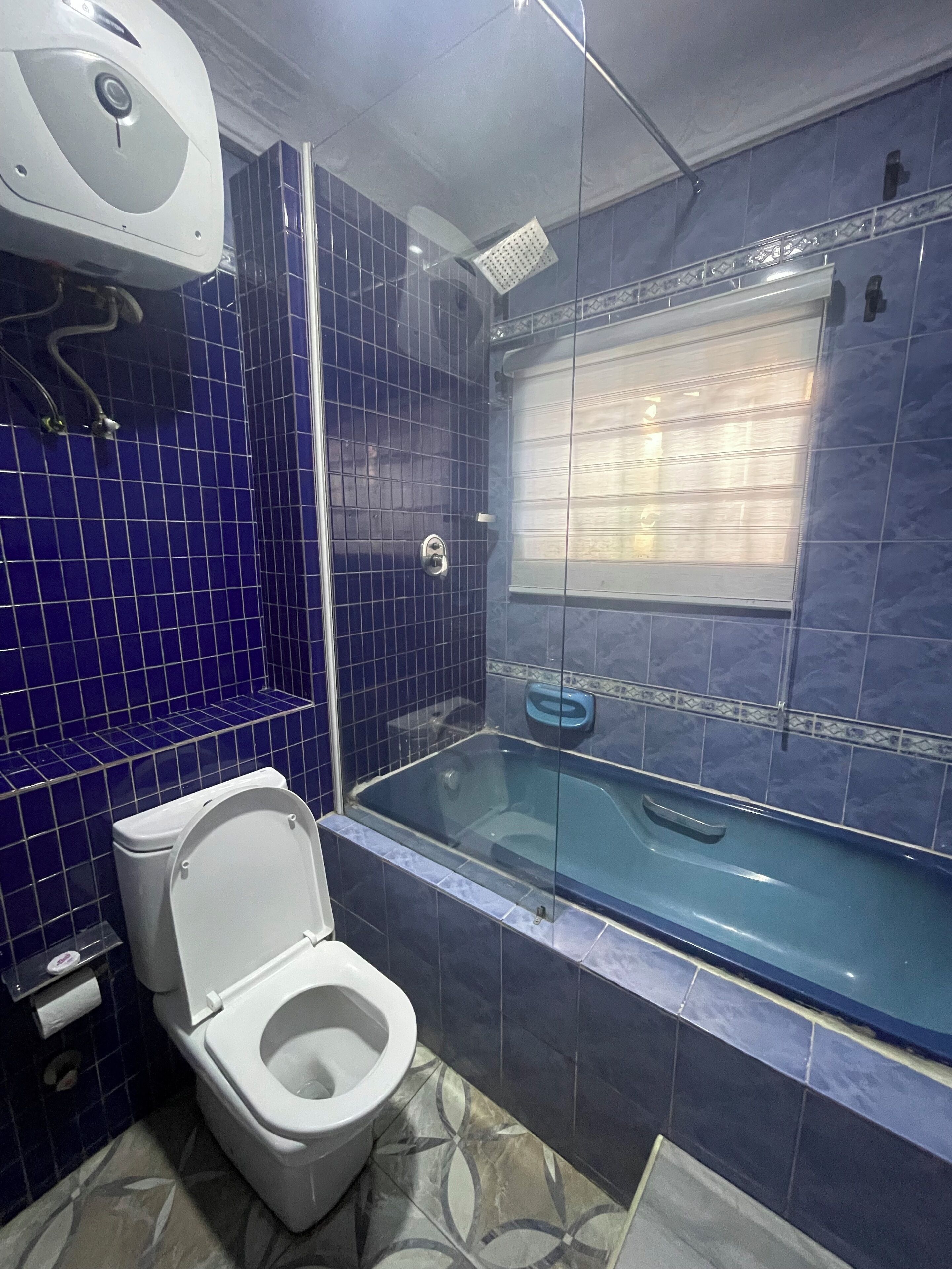 A bathroom with a toilet, a bathtub, and a shower.