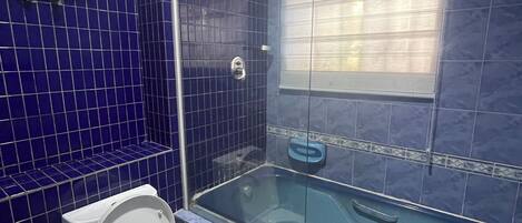 Un baño con inodoro, bañera y ducha.