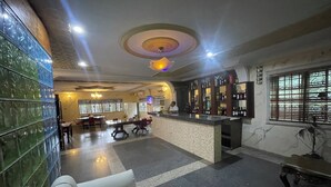 Ένας χώρος υποδοχής ξενοδοχείου με μπαρ, καθιστικά και ένα διακοσμητικό ταβάνι.