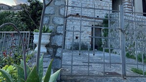 Un edificio de piedra con balcón y una verja.