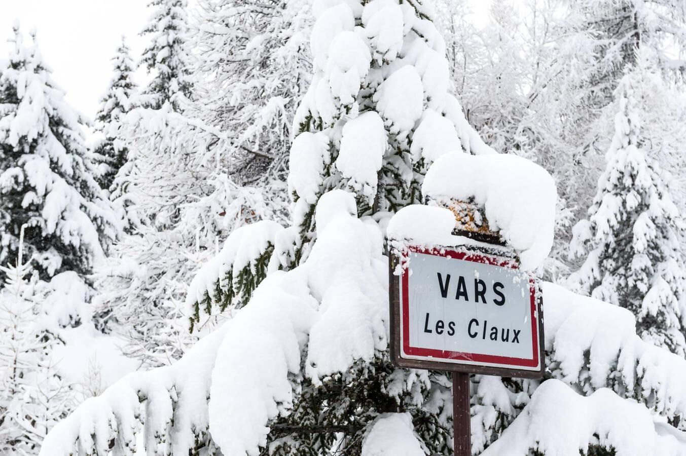 Een bord met de tekst 'VARS Les Claux' in een besneeerd landschap.