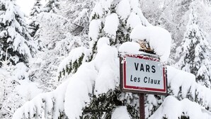 A sign with the text "VARS Les Claux" in a snowy landscape.