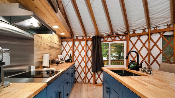 Eine moderne Küche mit Holzausstattung, Edelstahlgeräten und einem großen Fenster.