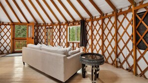 Ein gemütliches Interieur mit einer Couch, einem runden Tisch und einer Wand mit Gitterwerk.