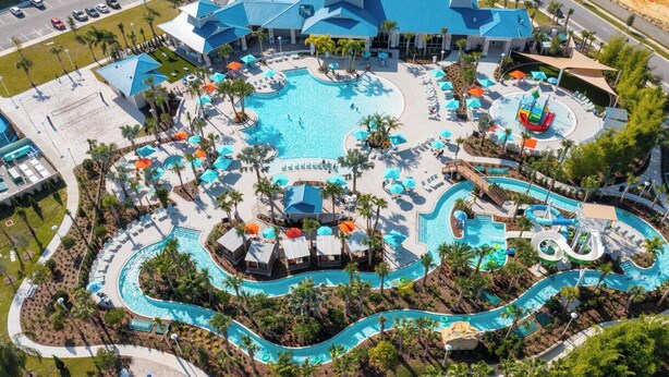An aerial view of a resort with multiple swimming pools, sun loungers, and a water park area. - DLuxx Beautiful Decor House fun Waterpark 1171 (Davenport)