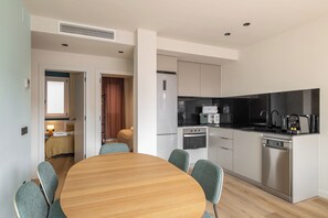Enjoy meals in the kitchen and dining area, featuring a refrigerator, oven, and dishwasher, with a dining table and four chairs.