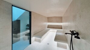 Ein modernes Badezimmer mit Glastür, einer Badewanne und einer Duschkabine.