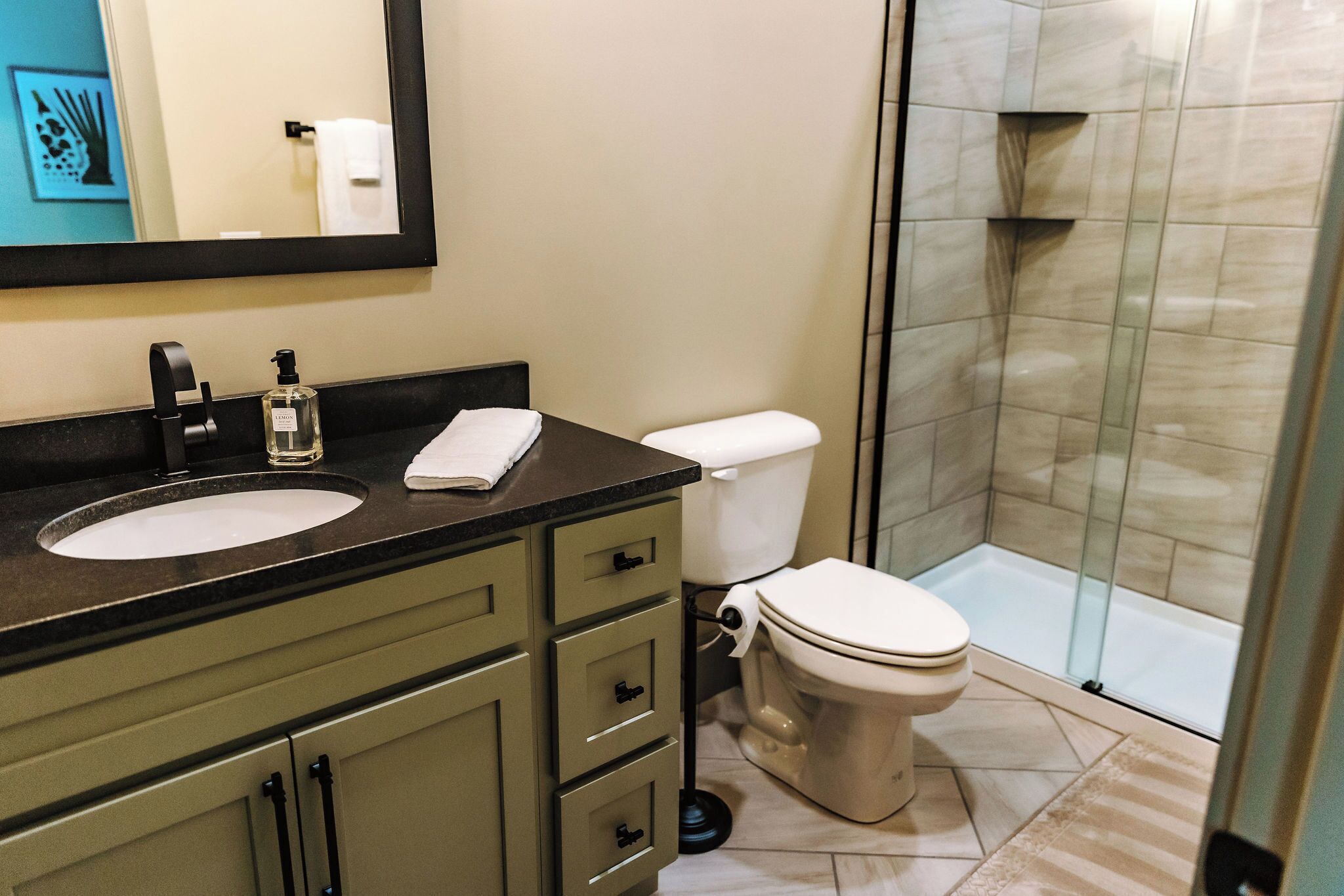 A bathroom with a sink, toilet, and glass-enclosed shower.