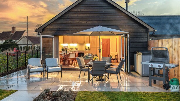A covered patio with outdoor furniture, a barbecue grill, and a view into the house. - UK47693 - Piglet Cottage (Wimbish)