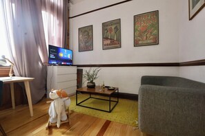 Relax in this cozy space with a TV, sofa, and educational posters on the walls.