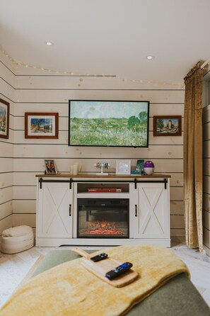 Smart-tv, een open haard, boeken en een stereo
