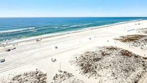 A wide sandy beach with a clear blue sky and calm sea. - Beachfront Bliss! Spacious 1,800 Sq ft 3BR Sleeps 12 - Oceans 9D - Gulfshores  (Gulf Shores)