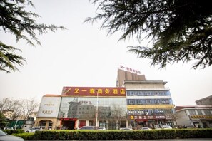 Un edificio de varios pisos con señalización que indica un hotel y locales comerciales.