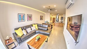 A modern living room with a sectional sofa, a wooden coffee table, and artwork on the walls. - Oceanview Penthouse Condo in Sunny Bucerias (Bucerias)