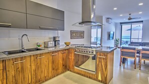 A modern kitchen with wooden cabinets, stainless steel appliances, and a large island. - Oceanview Penthouse Condo in Sunny Bucerias (Bucerias)