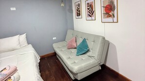A room with a bed, a sofa, and three framed artworks on the wall. - HOTEL PLAYA SURF BARÚ (Cartagena)