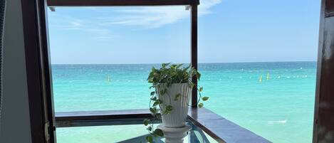 Une terrasse en bois avec une balustrade donnant sur des eaux turquoise.
