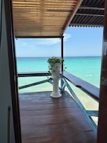 Una terraza de madera con barandilla que da a aguas turquesas.