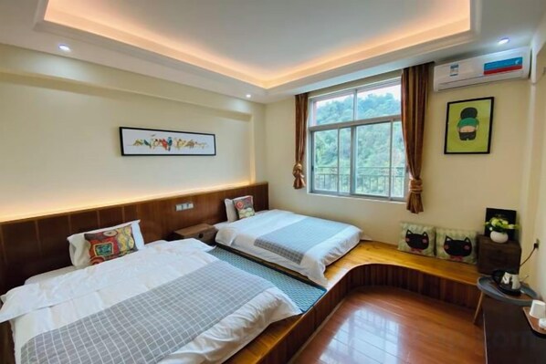 A hotel room with two beds, a window with curtains, a wall-mounted air conditioner, and a framed picture. - FenYangJu Hotel (Longmen)