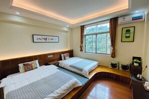 A hotel room with two beds, a window with curtains, a wooden bench, and a small table with a plant. - FenYangJu Hotel (Longmen)