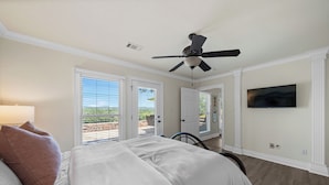 A bedroom with a bed, ceiling fan, and a TV on the wall. - The Overlook - best views on the lake!  (Hot Springs)