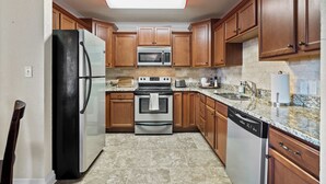 A kitchen with wooden cabinets, a stainless steel refrigerator, an oven, a microwave, and a dishwasher. - The Overlook - best views on the lake!  (Hot Springs)