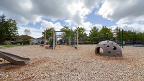 A playground with a slide, climbing structures, and a ball pit.
