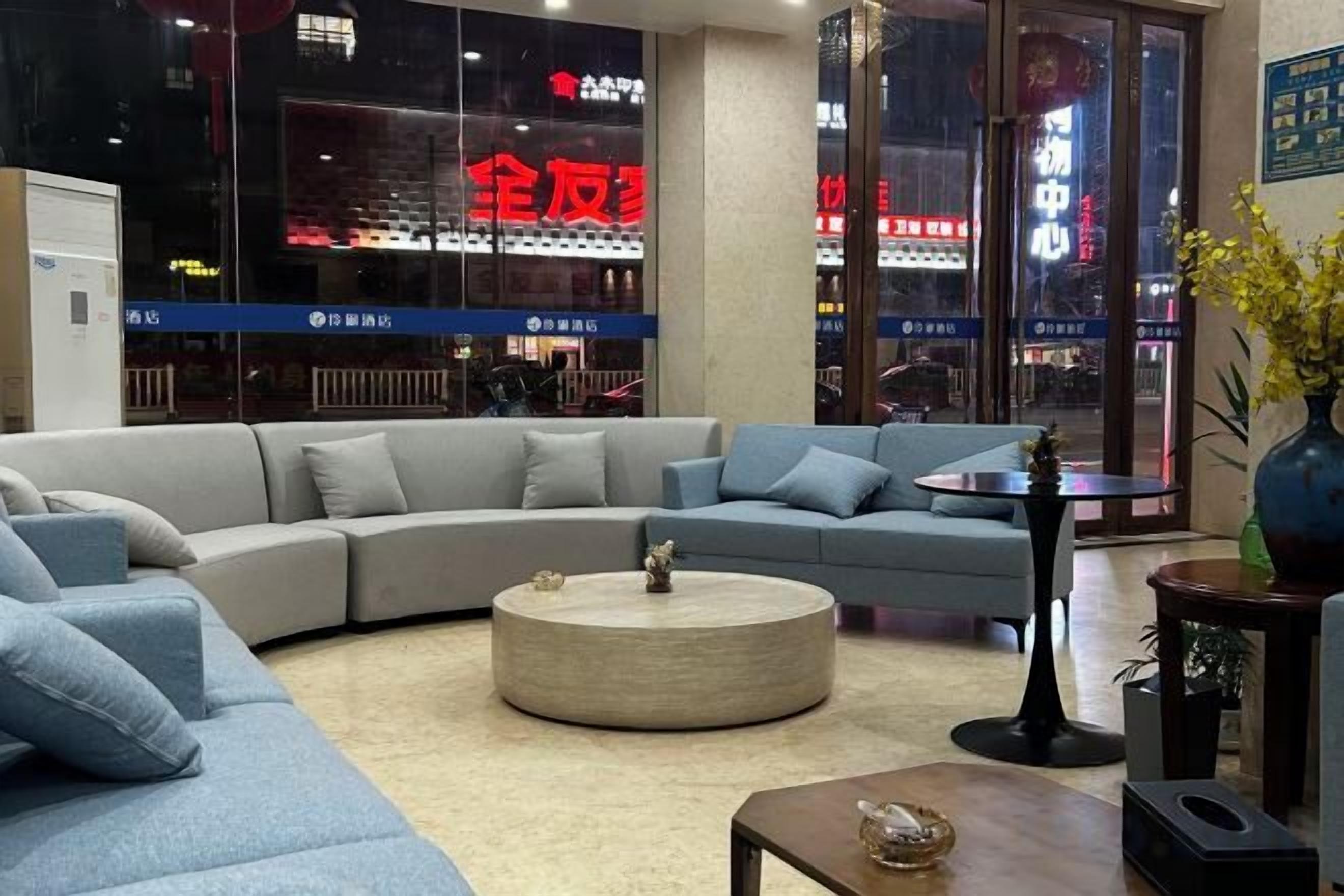 A modern living room with a sectional sofa, a round coffee table, and a small side table.