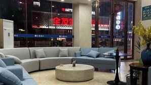 En moderne stue med en L-formet sofa, et rundt sofabord og et lille sidebord.