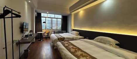 A hotel room with two beds, a desk, a chair, and a window with curtains.
