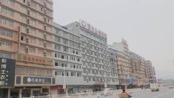 A multi-story building with commercial establishments on the ground floor, including a visible signboard.