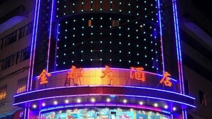 Un hôtel dont la façade est illuminée et qui affiche une enseigne dans une langue étrangère.