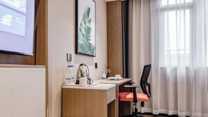 A hotel room with a wooden desk, a red chair, a projector screen, and a large window with curtains. - Kaiyang Jindu Hotel (Kaiyang)