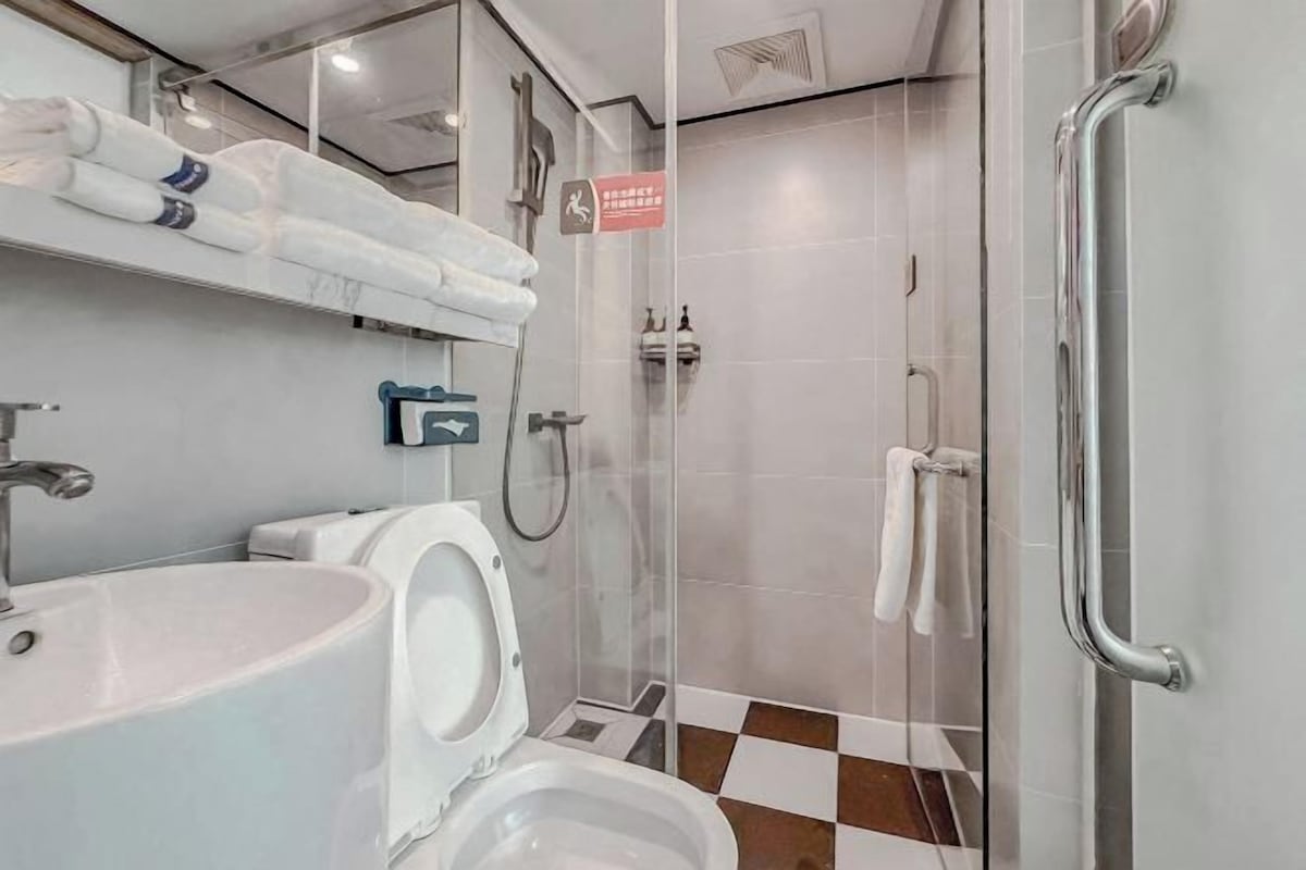 Een moderne badkamer met een wastafel, toilet en douche.
