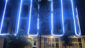 Een gevel met blauwe neonverlichting in rechthoekige vormen.