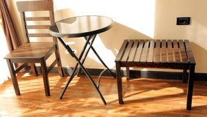Een houten stoel en tafel tegen een muur met een lichtschakelaar.