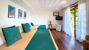 A hotel room with two beds, a TV, a small fridge, and a window with curtains. - Pousada Encanto de Buzios (Búzios)