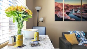 Una sala de estar moderna con encimera de mármol, un florero, una lámpara y un sofá con un cojín estampado.