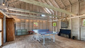 Un intérieur en bois avec une table de ping-pong, un banc et un panneau indiquant un club de tennis.
