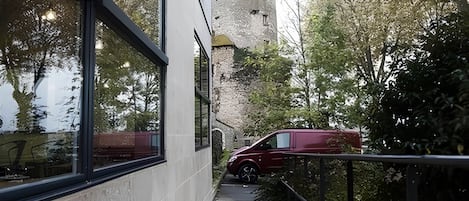 A modern building with large windows and a stone tower in the background.