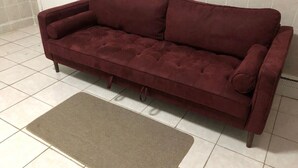 A maroon sofa with a matching throw rug on a tiled floor. - Private 1-bedroom apartment, 15 minutes to Manhattan, NYC bus at the door (Union City)