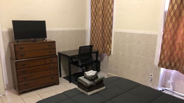 A bedroom with a bed, a dresser, a desk, a chair, and a television. - Private 1-bedroom apartment, 15 minutes to Manhattan, NYC bus at the door (Union City)