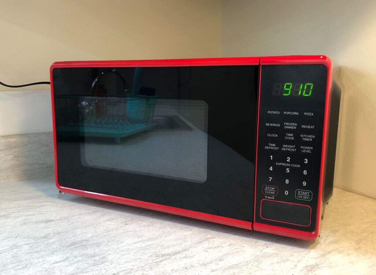 A red microwave oven with a digital display and a keypad.
