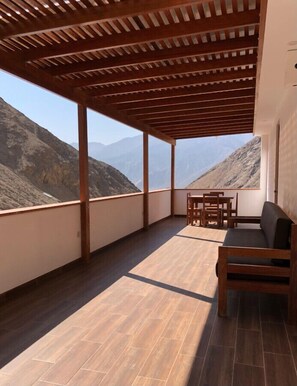 A balcony with a wooden pergola, a sofa, and a table with chairs. - Private 1 bedroom and 1 bathroom apartment with private entrance and private terrace and free Wi-Fi (Calango)
